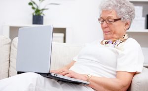 Image of person typing on a laptop accessing accessible healthcare insurance documents.