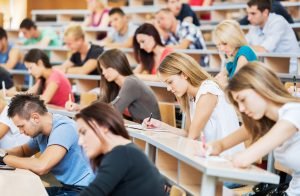 Large group of students taking standardized tests in lecture hall